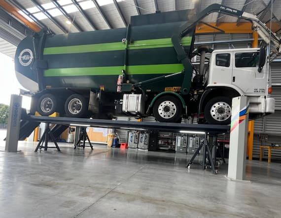 Velyen four-post lift installed by EquipSpecs with LED lighting upgrade for heavy vehicle servicing.