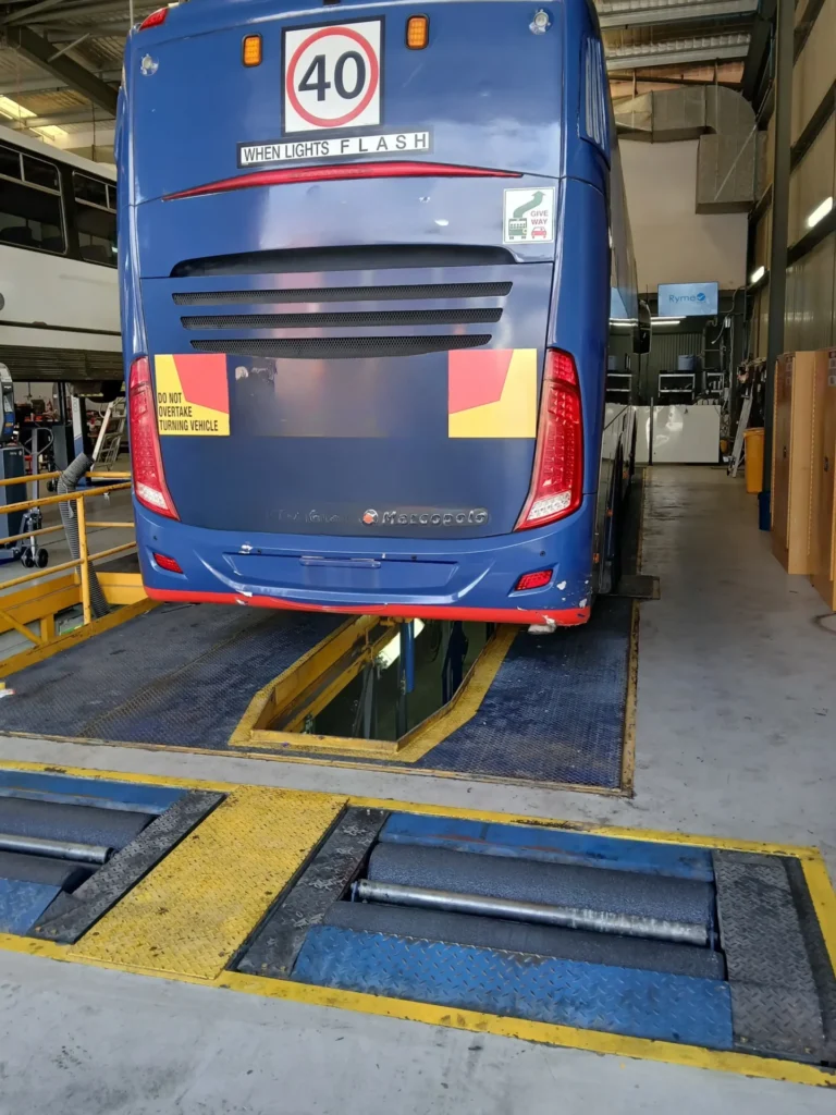 Heavy vehicle bus on in-ground roller brake tester in Sydney workshop with inspection pit Australia